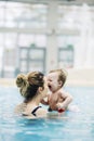 Mother with her baby daughter swim in the pool in waterpark