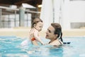 Mother with her baby daughter swim in the pool in waterpark