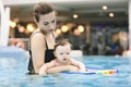 Mother with her baby daughter swim in the pool in waterpark