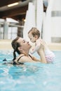 Mother with her baby daughter swim in the pool in waterpark