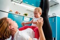 A mother with her baby doing fitness in the kitchen. Bottom view. The concept of home sports training with children Royalty Free Stock Photo