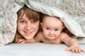 Mother and her baby playing and smiling under a blanket Royalty Free Stock Photo