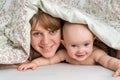 Mother and her baby playing and smiling under a blanket Royalty Free Stock Photo