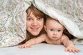 Mother and her baby playing and smiling under a blanket Royalty Free Stock Photo