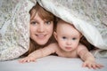 Mother and her baby playing and smiling under a blanket Royalty Free Stock Photo