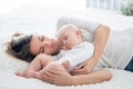 Mother and her baby son, sleeping on a big bed, soft back light Royalty Free Stock Photo