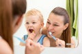 Mother and child brushing their teeth toothbrushes front of the mirror in the bathroom Royalty Free Stock Photo