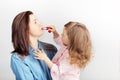 Mother and her child daughter girl with a lipstick. Portrait of