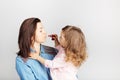 Mother and her child daughter girl with a lipstick. Portrait of