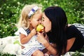 Mother and her child enjoy the early spring, eating apple, happy. Royalty Free Stock Photo