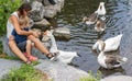 Mother and her child feed the geese in the pond Royalty Free Stock Photo