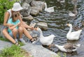 Mother and her child feed the geese in the pond Royalty Free Stock Photo