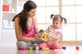 Mother and her child playing with colorful logical sorter toy Royalty Free Stock Photo