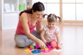 Mother and her child playing with colorful logical sorter toy Royalty Free Stock Photo