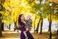 Mother and her child girl playing together on autumn walk in nature outdoors. Royalty Free Stock Photo