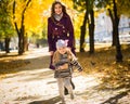 Mother and her child girl playing together on autumn walk in nature outdoors. Royalty Free Stock Photo