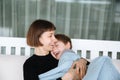 Mother and her child hugging on a swing, embracing with tenderness and care Royalty Free Stock Photo
