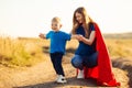 Mother and her child play together . Mom and son in superhero costumes. Mom and baby have fun, smile and hug Royalty Free Stock Photo