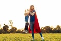 Mother and her child play together . Mom and son in superhero costumes. Mom and baby have fun, smile and hug Royalty Free Stock Photo