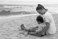 Mother and her child playing on the beach together outdoors Royalty Free Stock Photo
