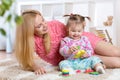 Mother and her child playing with colorful puzzle toy