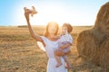 Mother and her child playing with toy airplane in spring field over soft sunlight Royalty Free Stock Photo