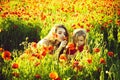 Mother with her child is resting in nature. red and green, mother and child in poppy field Royalty Free Stock Photo