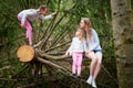 Mother and her child sister girls playing and having fun together on walk in forest outdoors. Happy loving family posing Royalty Free Stock Photo