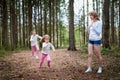 Mother and her child sister girls playing and having fun together on walk in forest outdoors. Happy loving family posing on nature Royalty Free Stock Photo