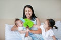 Mother and her children playing animal puppet on the bed room at home. Happy family concept Royalty Free Stock Photo