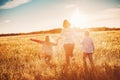 Mother with her children running on the field on the summer sunset. Royalty Free Stock Photo