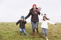 Mother And Her Children Running In The Park Royalty Free Stock Photo