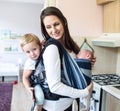Mother with her children in sling and baby carrier Royalty Free Stock Photo