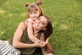 Mother with her cute child on green grass