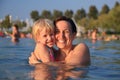 Mother with her cute child in water