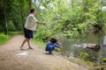 Mother and her cute little child feeding ducks in the pond in a park Royalty Free Stock Photo