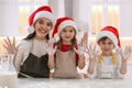 Mother and her cute little children having fun while making Christmas cookies in kitchen Royalty Free Stock Photo