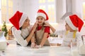 Mother with her cute little children having fun while making Christmas cookies in kitchen Royalty Free Stock Photo