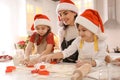 Mother and her cute little children making Christmas cookies in kitchen Royalty Free Stock Photo