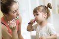 Mother and child brushing teeth together in the morning - dental care concept