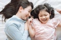 Mother and her daughter child girl hugging her mom in the bedroom .Happy Asian family. Royalty Free Stock Photo