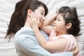 Mother and her daughter child girl hugging and Stroking her mom in the bedroom .Happy Asian family. Royalty Free Stock Photo