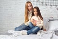 Mother and her daughter child girl playing and hugging on bed Royalty Free Stock Photo