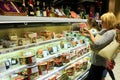 Mother and her daughter choicing cake on shelves of supermarket