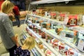 Mother and her daughter choicing cake on shelves of supermarket