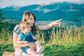 Mother with her daughter on her knees point somewhere Royalty Free Stock Photo