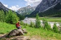 Mother and her daughter resting on large stone overlooking a mountain river . Travellig adventre and active vacation with children Royalty Free Stock Photo