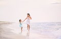 Mother and her daughter running and having fun on the beach Royalty Free Stock Photo