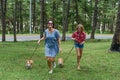 Mother and her daughter running with her corgi dogs in the forest Royalty Free Stock Photo