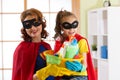 Mother and her daughter in Superhero costume. Mum and kid ready to house cleaning. Houseworking and housekeeping.